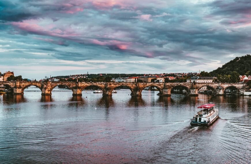 Stunning view of Charles Bridge with vibrant sunset hues over Vltava River in Prague.